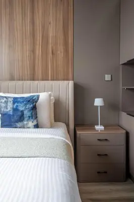 a bedroom with a bed and a night stand with a lamp at Frank Porter - Burj Views Central Tower in Dubai