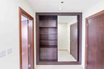 a dressing room with a mirror and a closet at Ensuite Rooms in CoLiving Apartments in Marina in Dubai