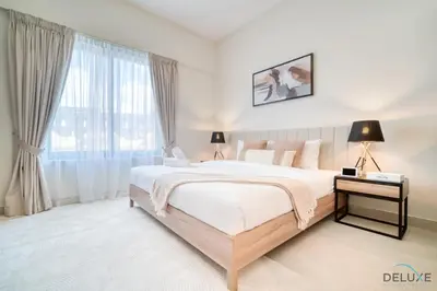 a bedroom with a large bed and a window at Stylish Studio Apartment at Casa Grande, JVC by Deluxe Holiday Homes in Dubai