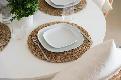 a white table with plates and napkins on top of a table at Elite Escape Holiday Home - 2 BHK Getaway with Dubai Mall Access - 1503 in Dubai