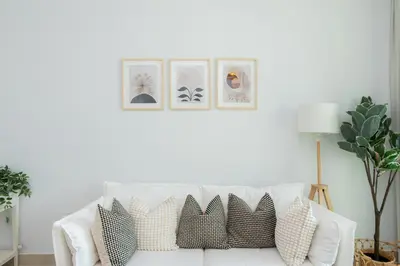 a living room with a white couch with pillows at Elite Escape Holiday Home - 2 BHK Getaway with Dubai Mall Access - 1503 in Dubai
