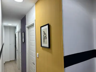 a hallway with a yellow wall with a picture on it at Prime Partition Room in Al Barsha 1 Near Metro in Dubai