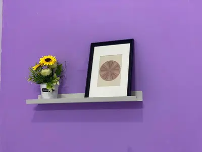 a white shelf with a picture and a vase of flowers at Individual Partition Room in Al Barsha 1 Near Mashreq Metro in Dubai