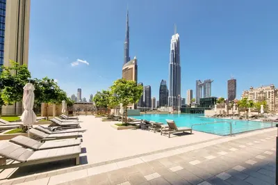 a swimming pool with lounge chairs and a city skyline at Burj Khalifa view Lux 3 bedroom by Tanami Holiday Homes in Dubai