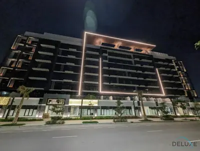 a large building with lights on it at night at Pleasant Studio Apartment at Azizi Riviera 13, Al Merkadh by Deluxe Holiday Homes in Dubai