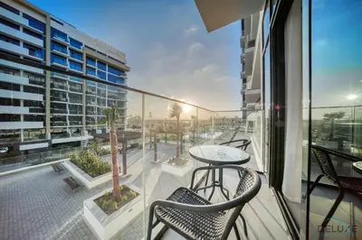 a balcony with a table and chairs and a building at Pleasant Studio Apartment at Azizi Riviera 13, Al Merkadh by Deluxe Holiday Homes in Dubai