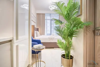 a bedroom with a bed and a potted plant at Comfortable Studio Apartment at Azizi Riviera 30, Al Merkadh by Deluxe Holiday Homes in Dubai