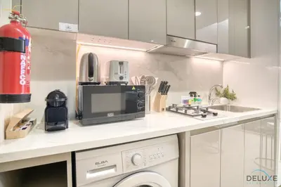 a kitchen with a microwave oven and a sink at Comfortable Studio Apartment at Azizi Riviera 30, Al Merkadh by Deluxe Holiday Homes in Dubai