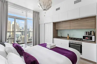 a bedroom with a large bed and a kitchen at Summer offer! All Inclusive! Prime Location in Dubai