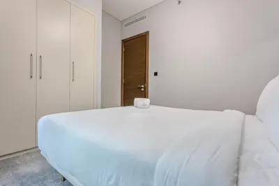 a bedroom with a white bed with a candle on it at STAY BY LATINEM Luxury 1BR Holiday Home CVR A2403 near Burj Khalifa in Dubai