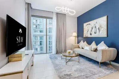a living room with a couch and a tv at STAY BY LATINEM Luxury 1BR Holiday Home CVR A2403 near Burj Khalifa in Dubai