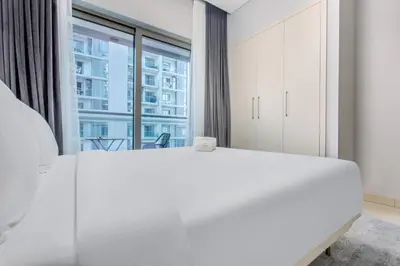 a bedroom with a white bed and a large window at STAY BY LATINEM Luxury 1BR Holiday Home CVR A2403 near Burj Khalifa in Dubai