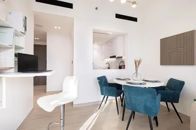 a kitchen and dining room with a table and chairs at Spacious Balcony, King Bed, Pool at JVC Dubai in Dubai