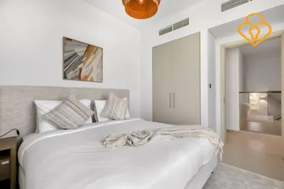 a bedroom with a large white bed with an orange ribbon at Keysplease Wonderful 4 B/R Home with Garden Arabian Ranches in Dubai