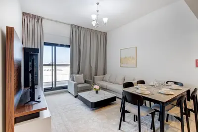 a living room with a table and a couch at Mira Holiday Homes -Newly 2 bedroom close to metro. in Dubai