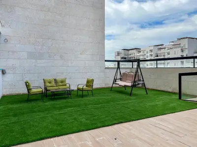 a patio with chairs and a swing on a roof at Mira Holiday Homes -Newly 2 bedroom close to metro. in Dubai