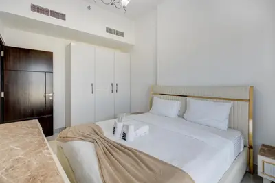 a bedroom with a white bed with two boxes on it at Mira Holiday Homes -Newly 2 bedroom close to metro. in Dubai