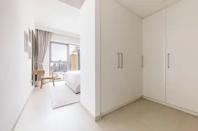 a white bedroom with a bed and a window at Stunning 2 Bedroom Apartment with Burj Views by Zen Stays - Walking Distance to Dubai Mall in Dubai