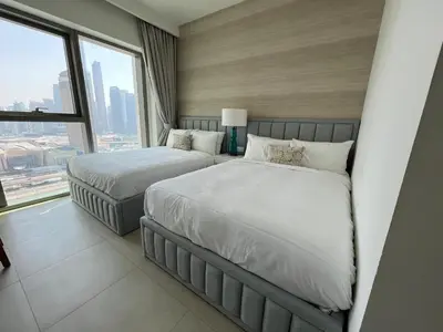 a bedroom with two beds and a large window at Stunning 2 Bedroom Apartment with Burj Views by Zen Stays - Walking Distance to Dubai Mall in Dubai