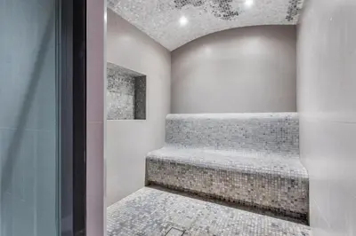 a walk in shower with a bench in a room at STAY BY LATINEM Luxury 1BR Holiday Home CVR A2504 near Burj Khalifa in Dubai