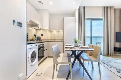 a kitchen and dining room with a table and chairs at STAY BY LATINEM Luxury 1BR Holiday Home CVR A2504 near Burj Khalifa in Dubai