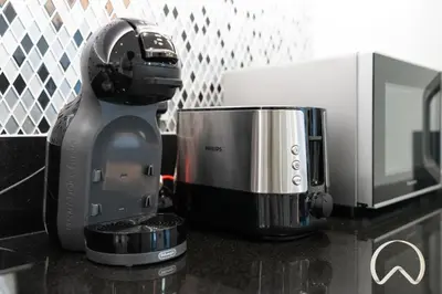 a coffee maker sitting on a counter next to a microwave at Oraya - Paramount Midtown Luxurious 2BR with Sea View in Dubai