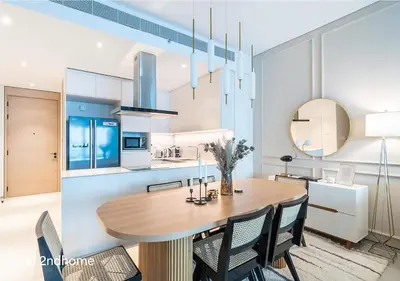 a kitchen and dining room with a wooden table and chairs at 2ndHome - Address Beach Resort, Tower 1, JBR in Dubai