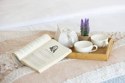 a tray with a book and cups and a vase at Salt of the Ocean in JBR by Lagom in Dubai