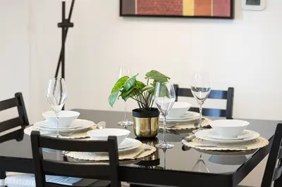 a black dining room table with glasses and a plant at Salt of the Ocean in JBR by Lagom in Dubai