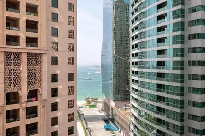a view of the ocean between two tall buildings at Salt of the Ocean in JBR by Lagom in Dubai