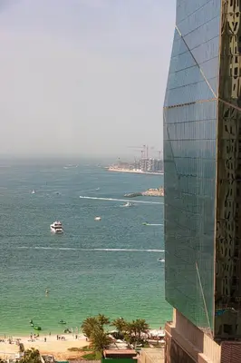 a building next to a beach with a boat in the water at Salt of the Ocean in JBR by Lagom in Dubai