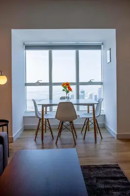 a dining room with a table and chairs and a large window at Deluxe - Sea view - Dubai Marina in Dubai