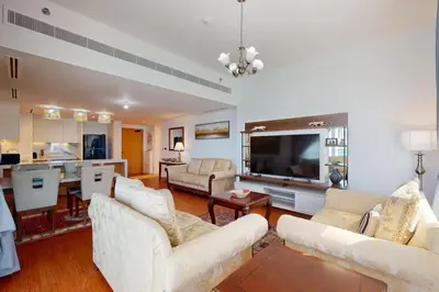 a living room with two white couches and a television at La Vie, JBR - Cosy Two Bedroom in Dubai