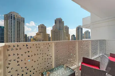 a balcony with chairs and a view of the city at La Vie, JBR - Spacious One Bedroom in Dubai