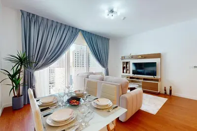 a living room with a table and a couch at La Vie, JBR - Spacious One Bedroom in Dubai