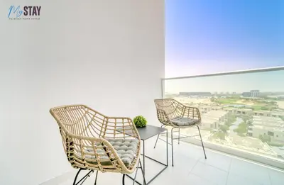two chairs and a table in a room with a window at Lovely One Bedroom Apartment in Dubai