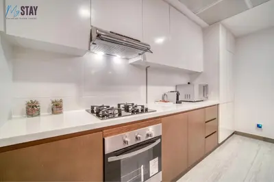 a kitchen with a stove and a microwave at Luxurious Two-Bedroom Apartment in Dubai
