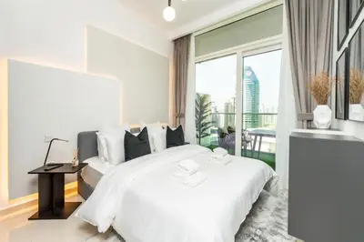 a bedroom with a white bed and a large window at The Dreamer 1BR Burj Khalifa View Business Bay in Dubai