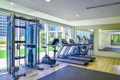 a gym with several treadmills and elliptical machines at The Dreamer 1BR Burj Khalifa View Business Bay in Dubai