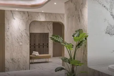 a bathroom with a mirror and a bench and a plant at The Cinephile Burj Khalifa View 2BR Dubai in Dubai