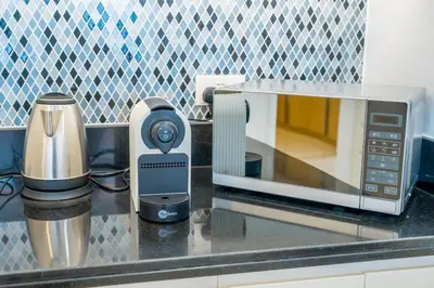 a microwave sitting on a kitchen counter next to a appliance at The Cinephile Burj Khalifa View 2BR Dubai in Dubai