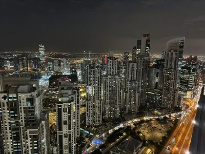 a large city at night with cars at The Cinephile Burj Khalifa View 2BR Dubai in Dubai
