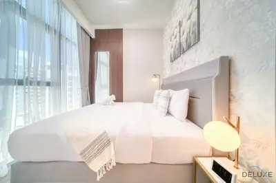 a bedroom with a white bed and a large window at Serene 1BR Apartment in Azizi Riviera 27, Al Merkadh by Deluxe Holiday Homes in Dubai