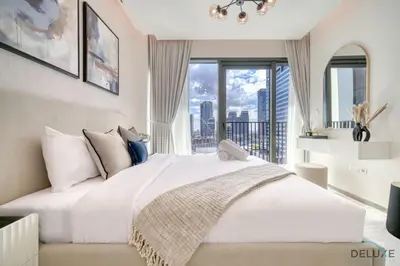 a bedroom with a large white bed with a large window at Welcoming 1BR Apartment in Ahad Residences Business Bay by Deluxe Holiday Homes in Dubai