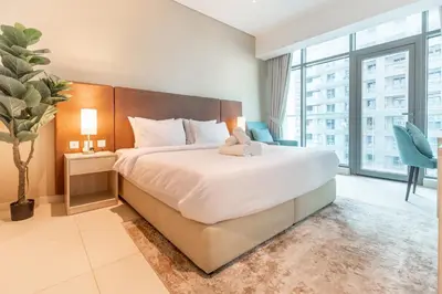 a bedroom with a bed with a stuffed animal on it at SEVEN PALM by Design Studio 1BR in Dubai