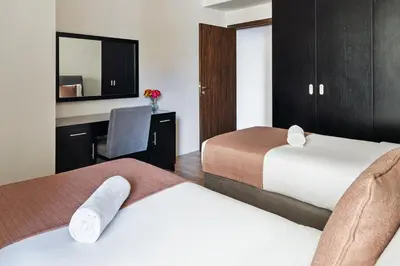 a hotel room with two beds and a desk at Stunning 3 plus 1 BR Apartment on JBR Beach with Marina View Near Mall, Metro & Cinemas - By Sunkissed Holiday Homes in Dubai