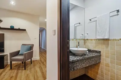 a bathroom with a sink and a chair at Stunning 3 plus 1 BR Apartment on JBR Beach with Marina View Near Mall, Metro & Cinemas - By Sunkissed Holiday Homes in Dubai