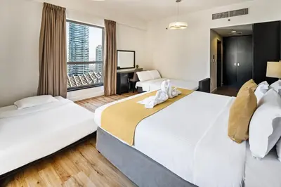 two beds in a hotel room with a window at Stunning 3 plus 1 BR Apartment on JBR Beach with Marina View Near Mall, Metro & Cinemas - By Sunkissed Holiday Homes in Dubai