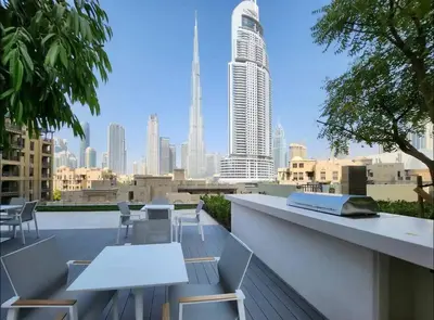 a rooftop patio with tables and chairs and a city skyline at *Views of Burj Khalifa Fountain* in Dubai