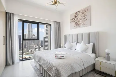 a white bedroom with a large bed and a large window at *Views of Burj Khalifa Fountain* in Dubai
